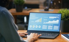 An image showing a person  looking at a computer screen with data analysis