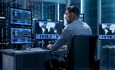 An image depicting a person working with data with multiple screens